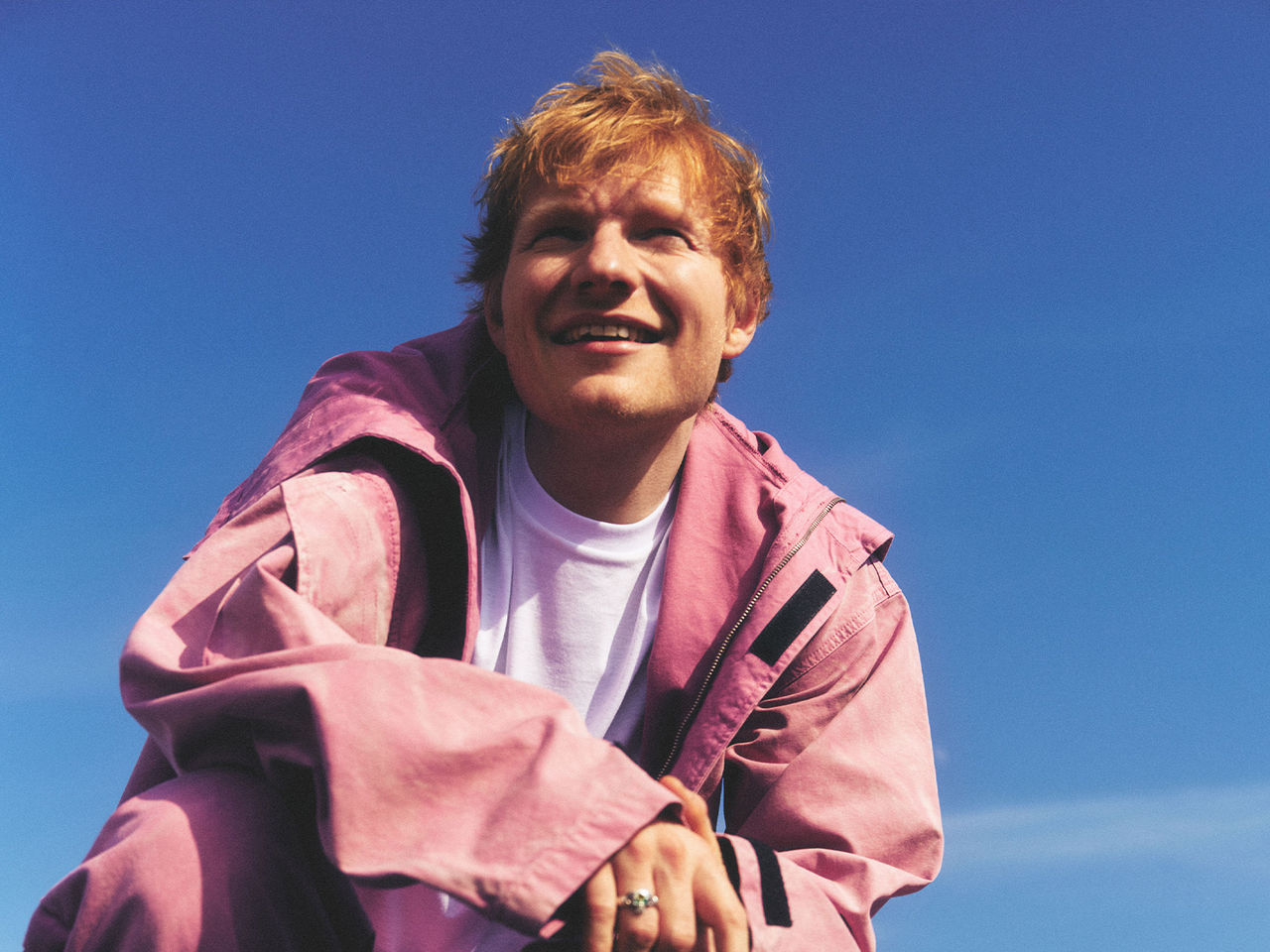 Ed Sheeran crouching and looking into the distance by Petros Studio