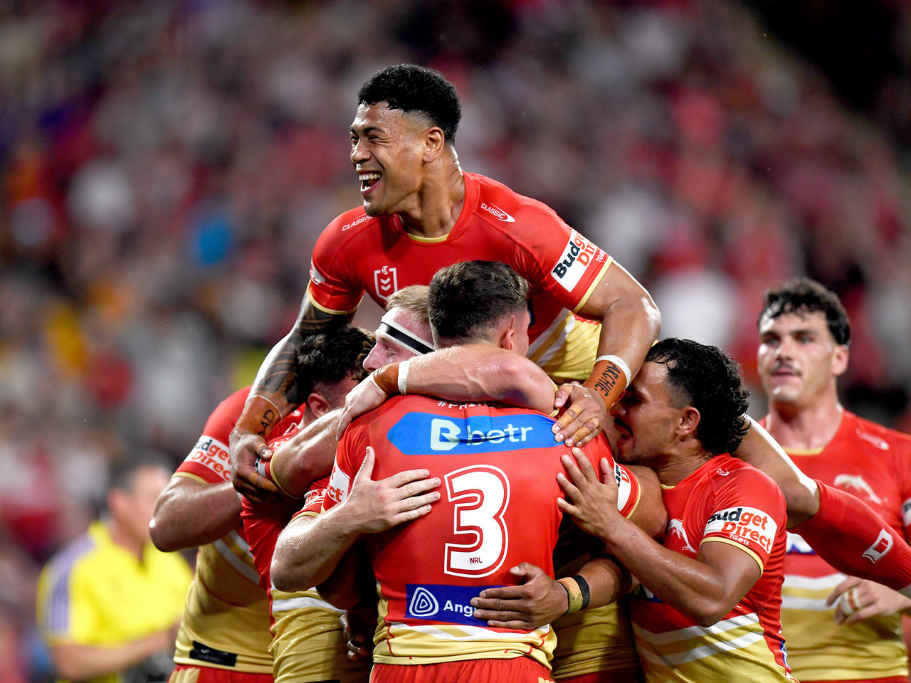 Dolphins players celebrate scoring a try as Jamayne Isaako jumps on top of the group with a big smile