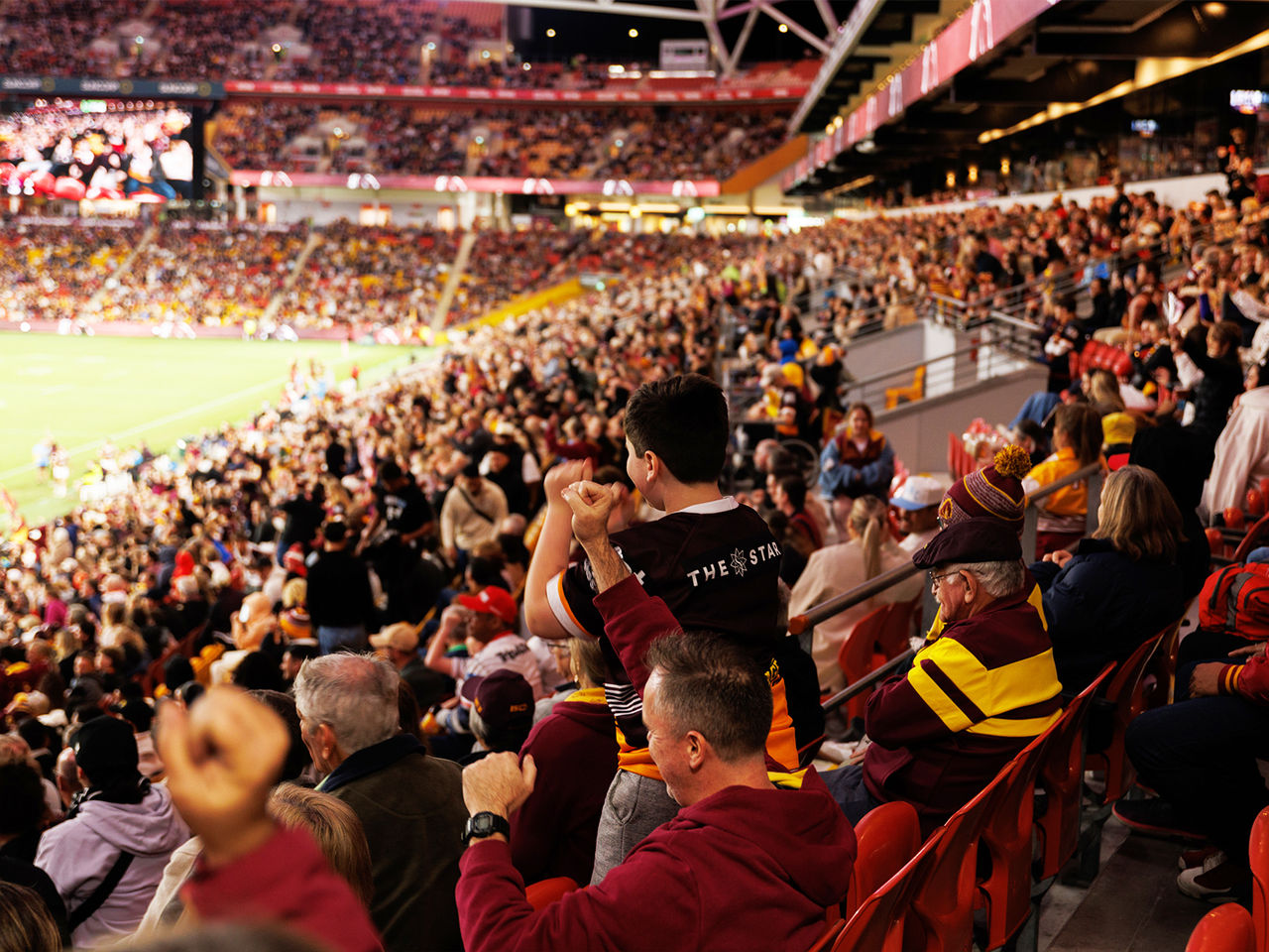Fans in the stands watching a Brisbane Broncos game at Suncorp Stadium