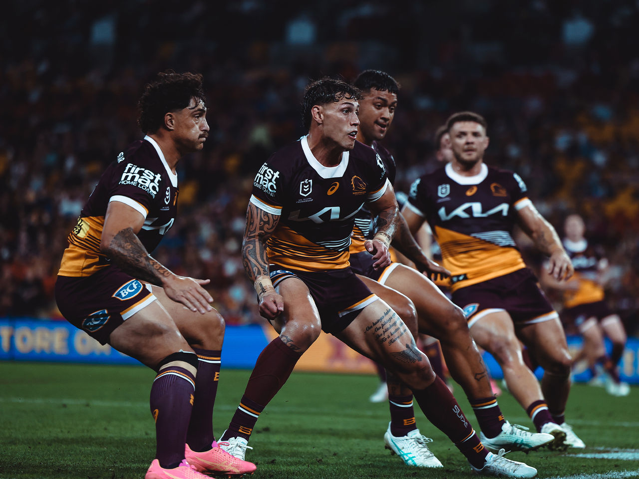 Brisbane Broncos players about to make a tackle 