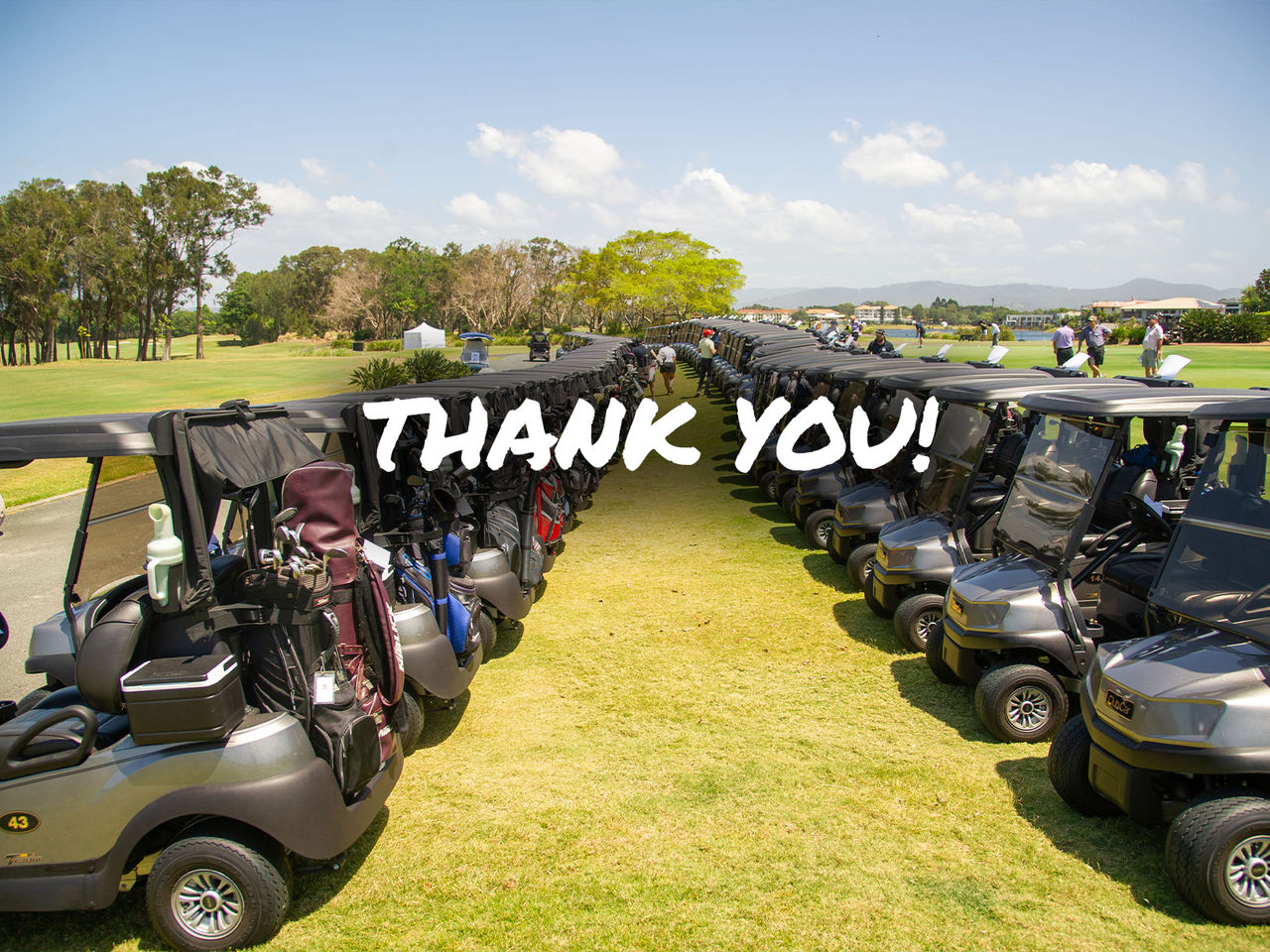 Image of two lines of golf carts on the golf green on a sunny dat. There is white text across the image that says thank you!