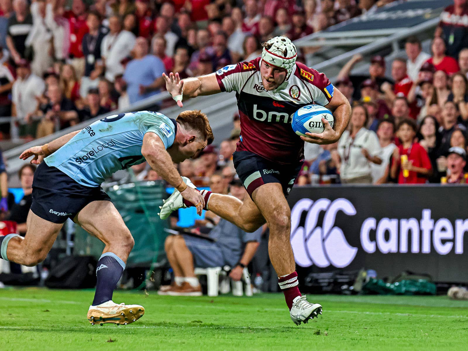 Reds player fending off a NSW Waratahs player