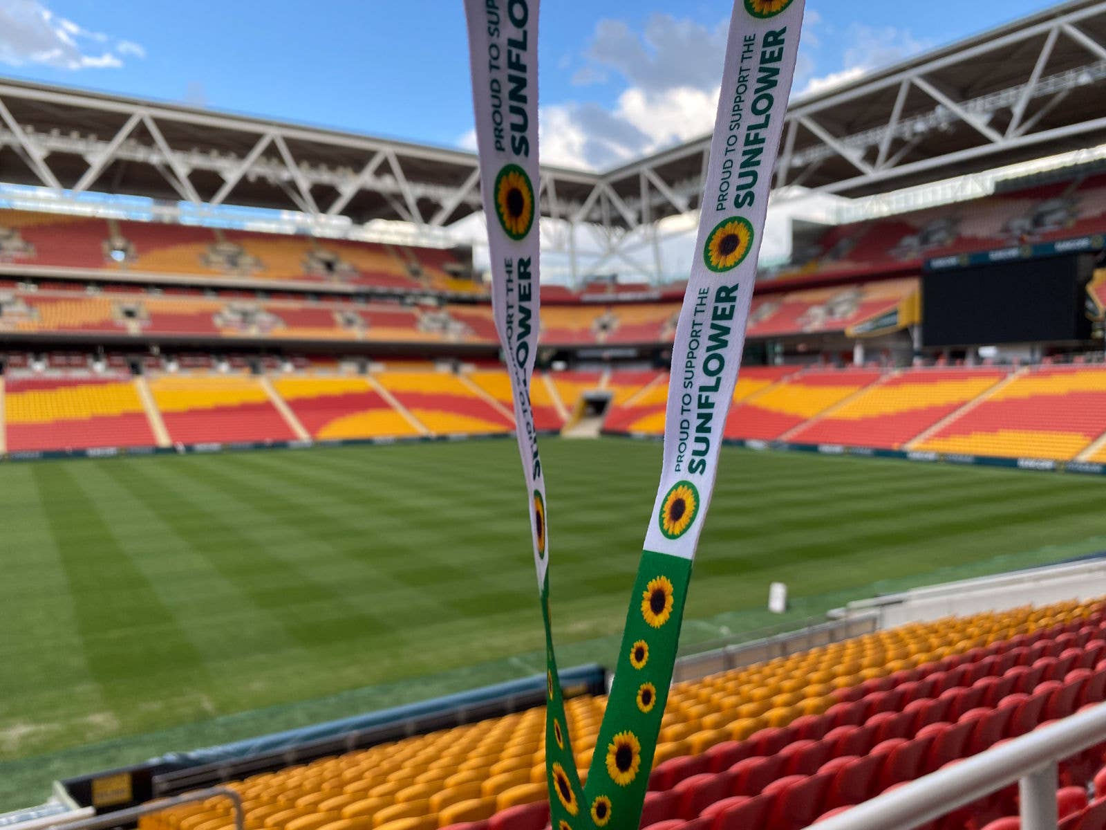 A sunflower program lanyard with the Suncorp Stadium field in the background