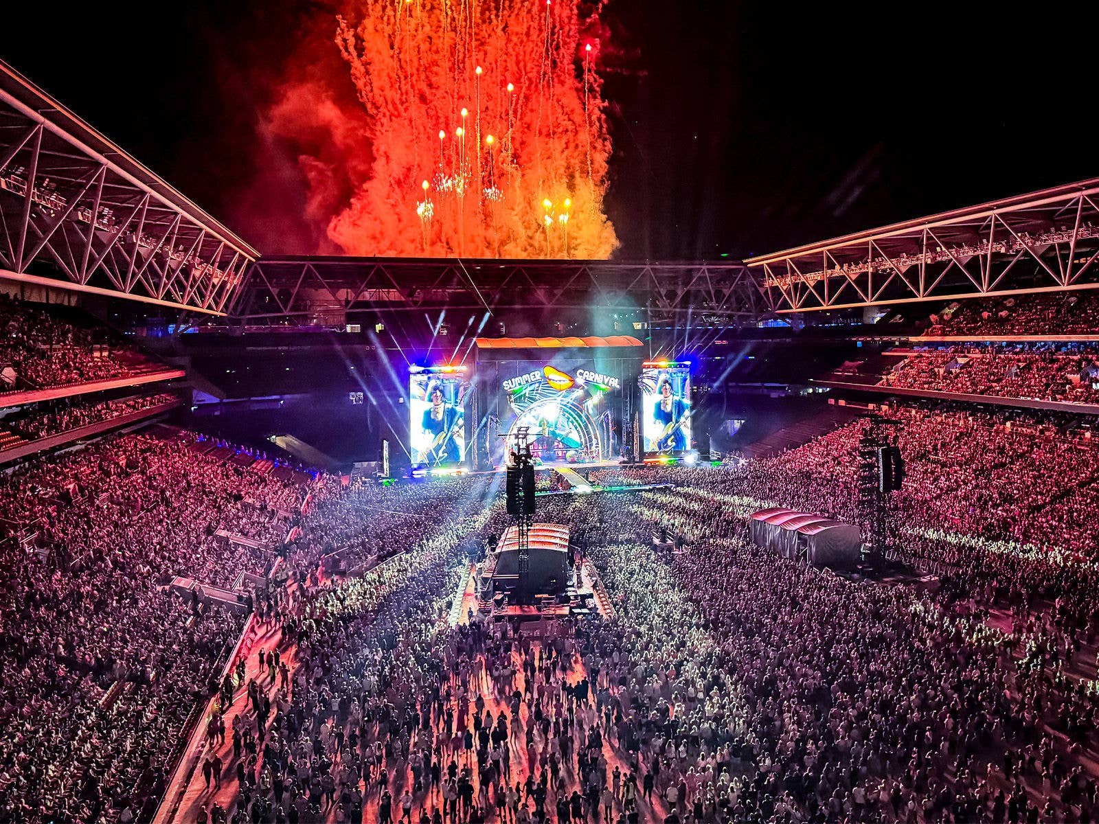 Suncorp Stadium full of fans during a concert and fireworks going off the roof
