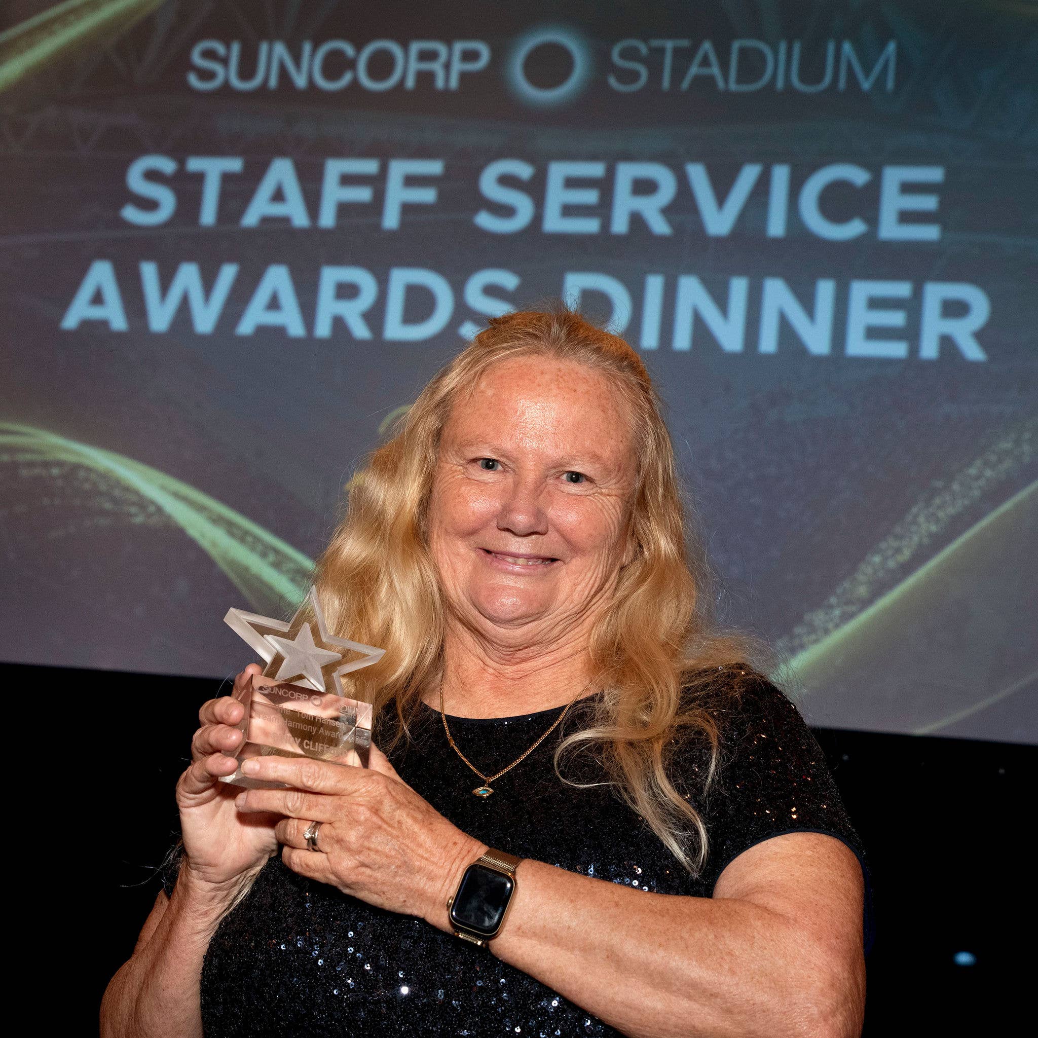 Photo of Cindy Clifford holding the Team Harmony Award