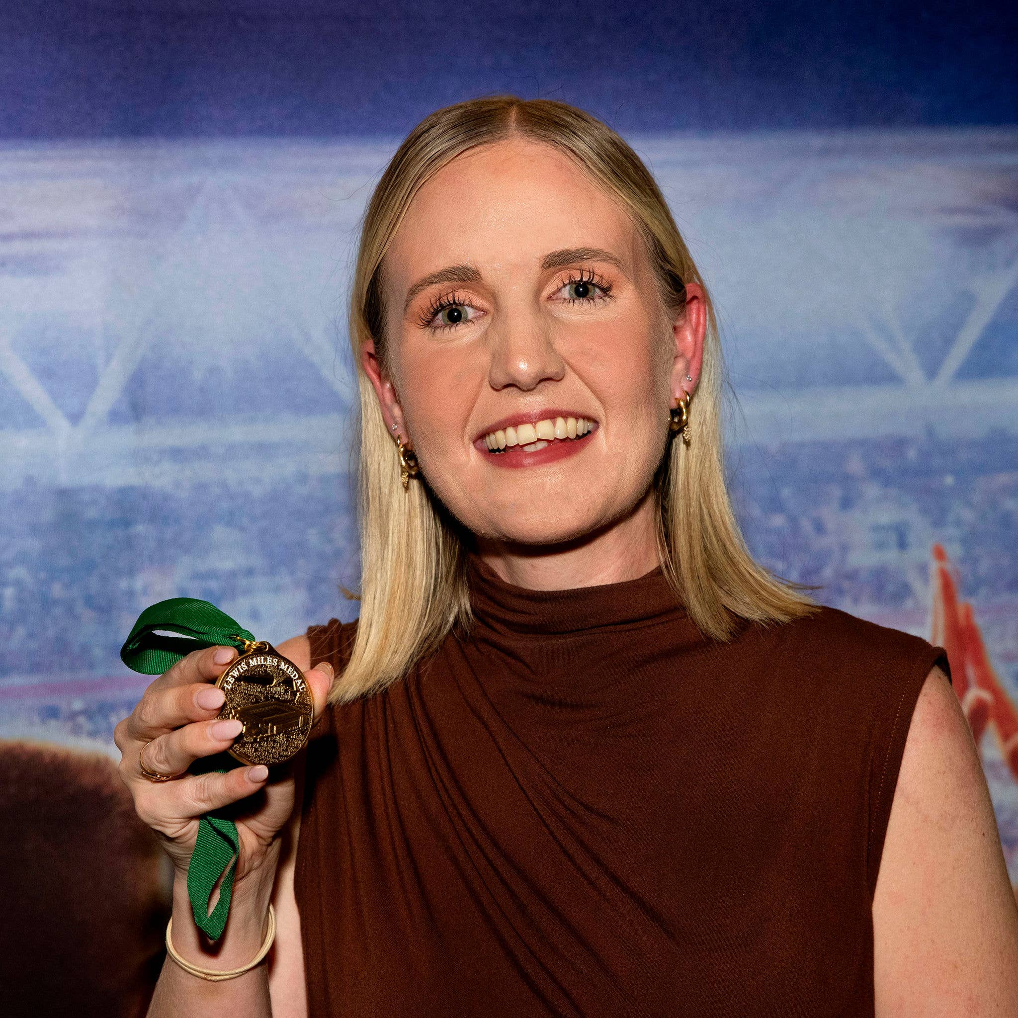 Photo of Eilish McNeill-Sheldon holding the Lewis Miles Medal