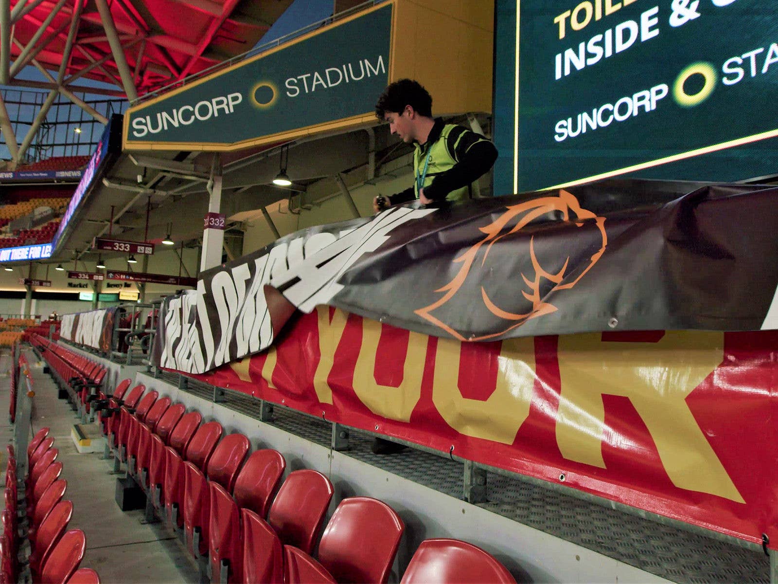 Suncorp Stadium staff changin Broncos signage to Dolphins signage