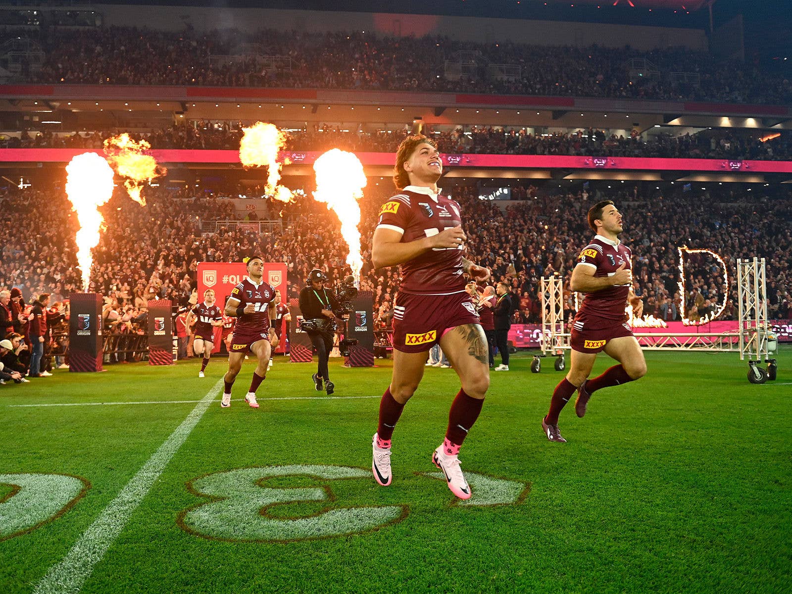 Queensland players Reece Walsh and Ben Hunt running out for an origin game at Suncorp Stadium in front of a full crowd and pyro