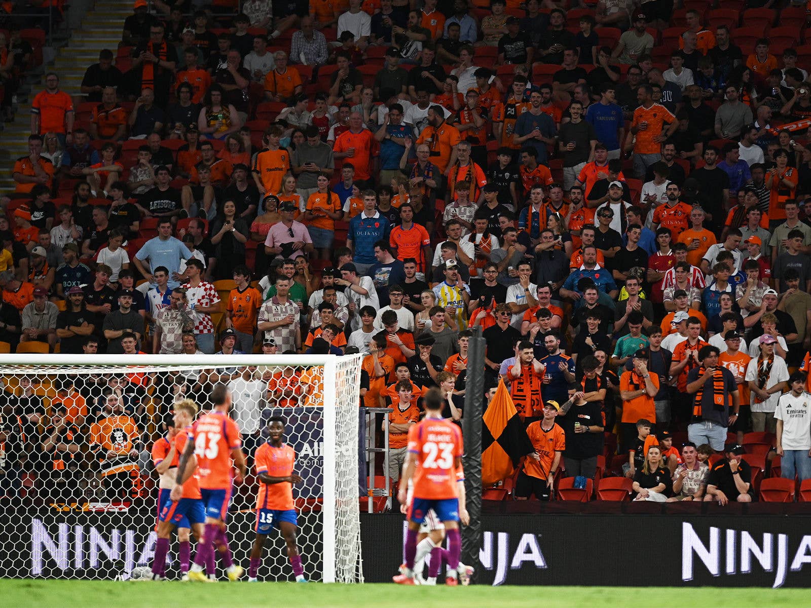 The Brisbane Roar ready to defend a cross with the Den supporters in the background