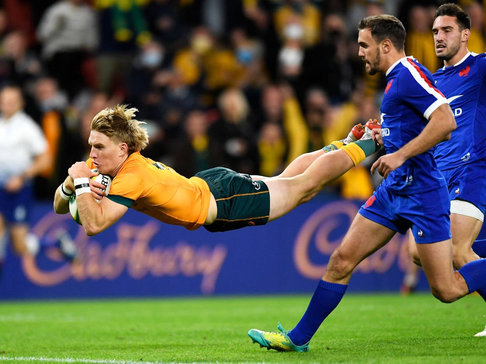 Wallabies player leaping to score a try while France attempt to defend