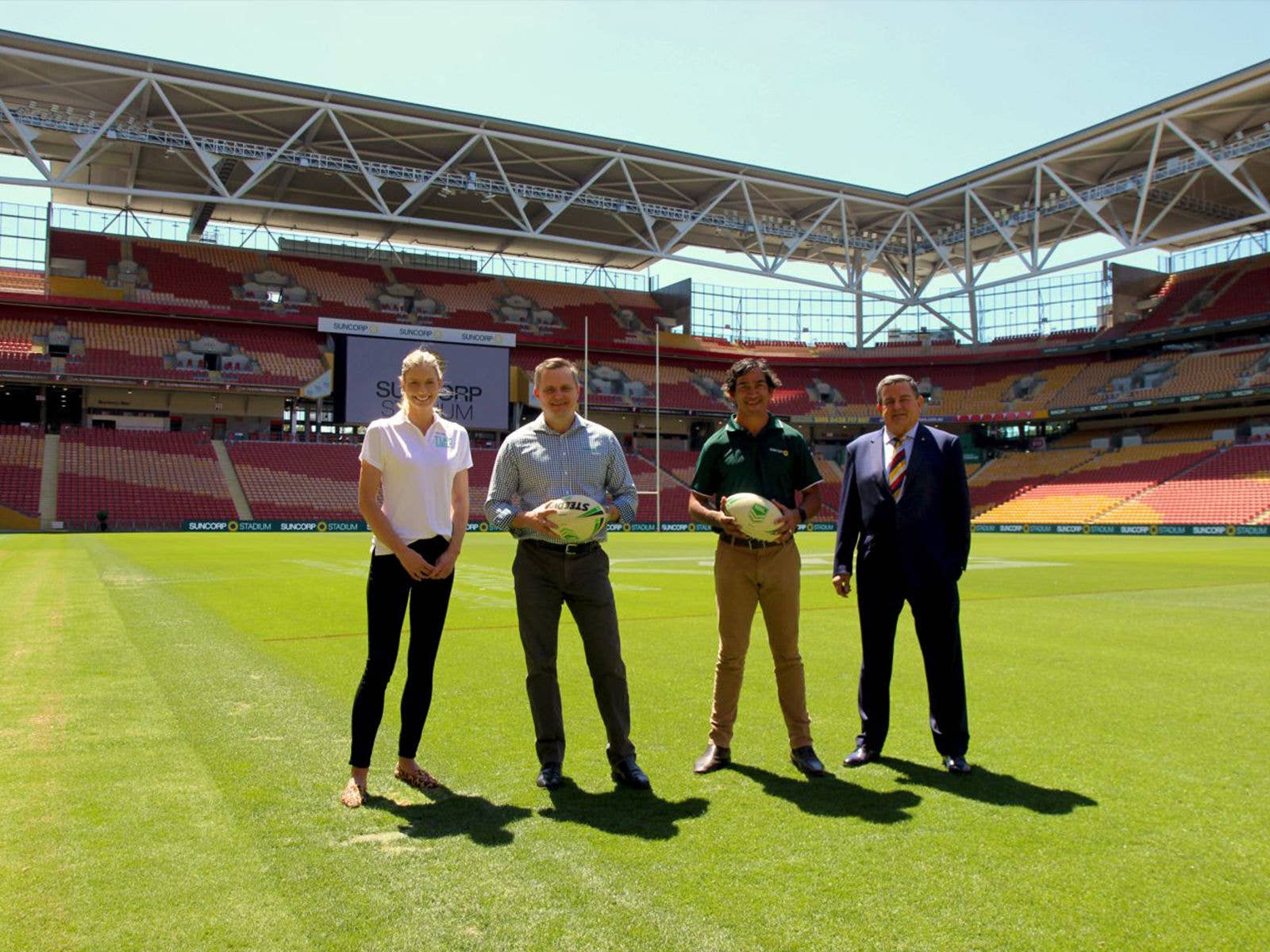 Netball champion Laura Geitz, Suncorp Group CEO Steve Johnston, NRL legend Johnathan Thurston and Chairman and Chief Executive of ASM Global Harvey Lister AM standing at Suncorp Stadium