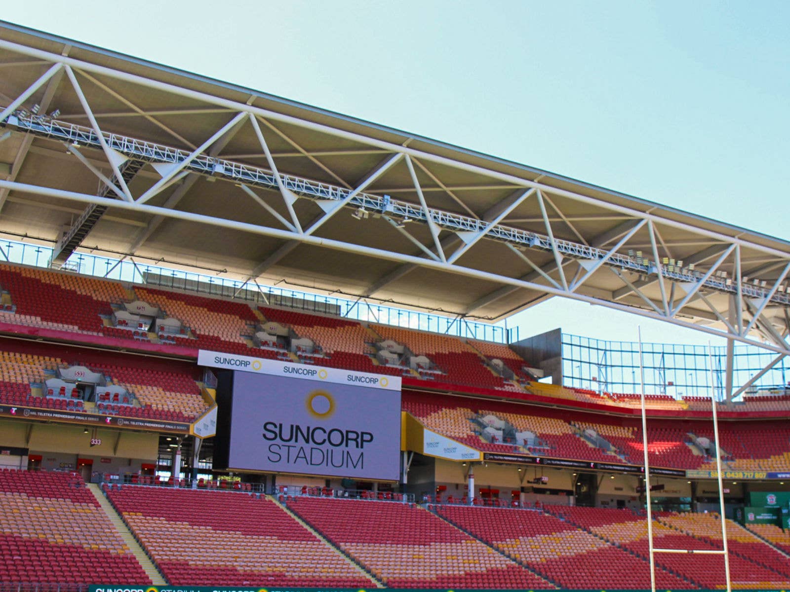 Suncorp Renews It's Partnership with the Stadium for up to 10 More Years. Image of Suncorp Stadium seating bowl on a sunny day. The Suncorp Stadium logo is displayed on the big screen.
