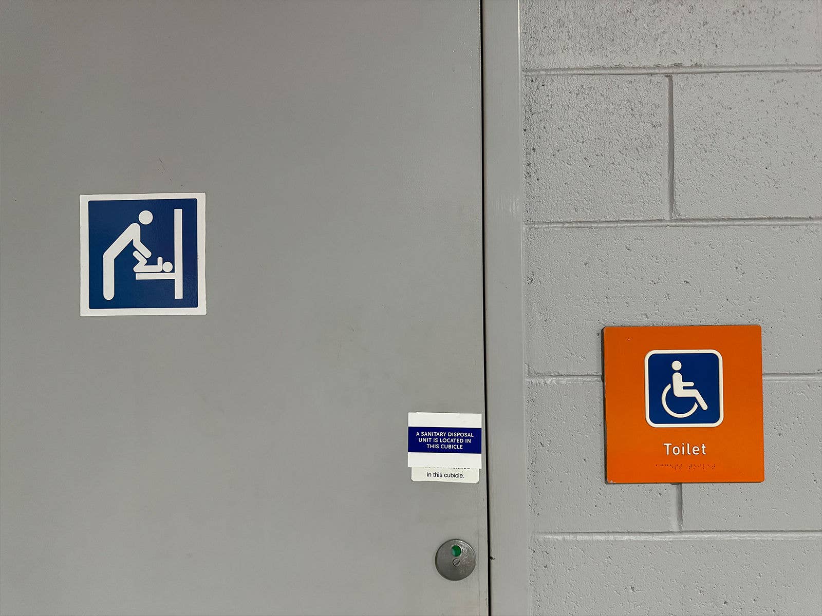 An image of a PWD toilet door with a baby change room sign on it