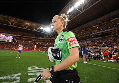 Belinda Sharpe on the Suncorp Stadium field holding a football.