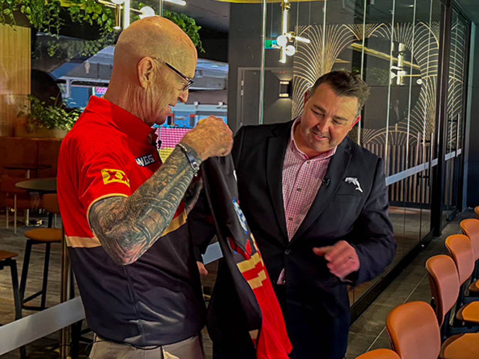 Suncorp Stadium Staff Saved A Life. Image of Patron Doug (Left) being presented with a Dolphins Jersey by Dolphins CEO Terry Reader (Right).