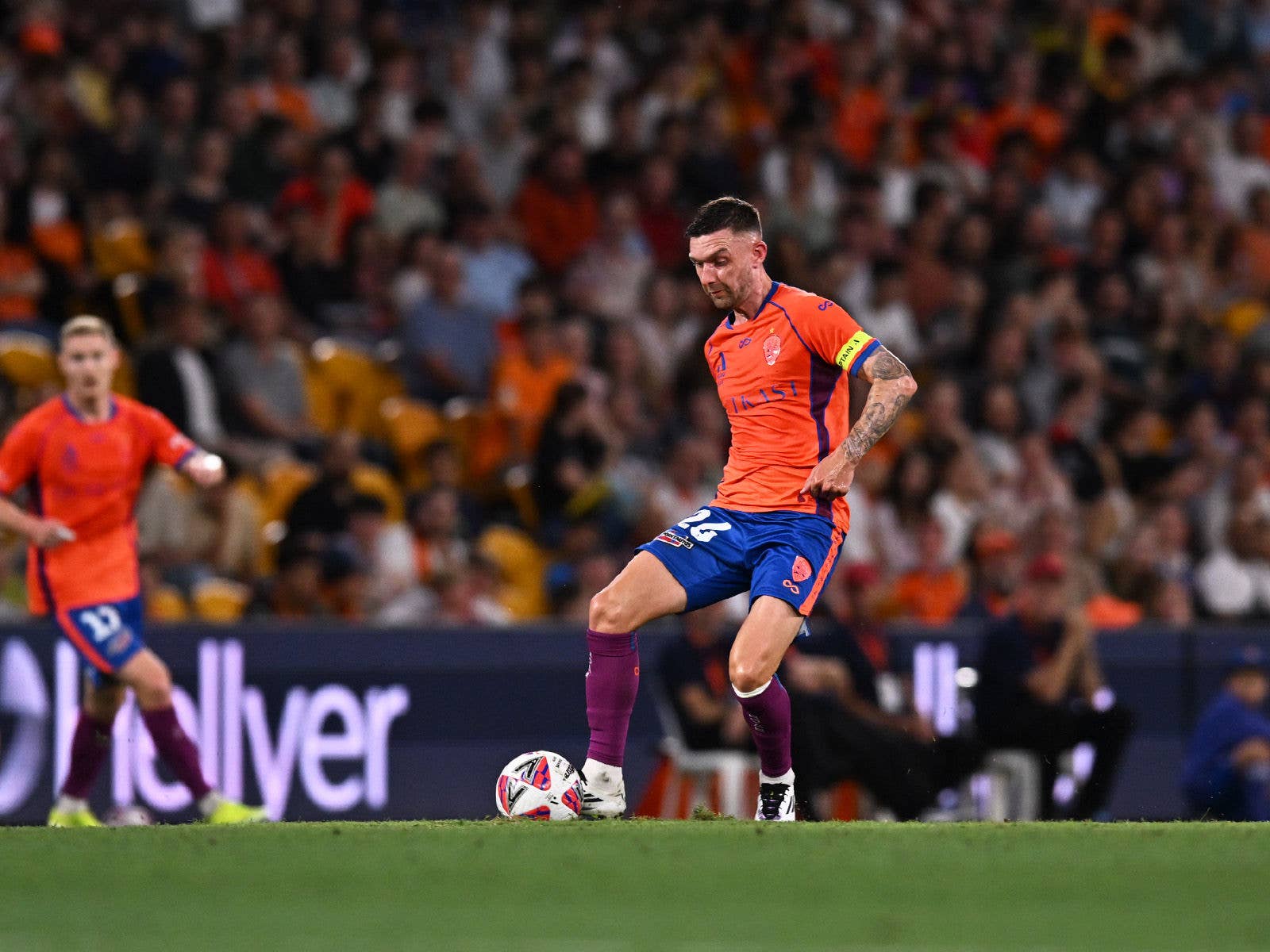 Brisbane Roar player kicking the ball at Suncorp Stadium during a game