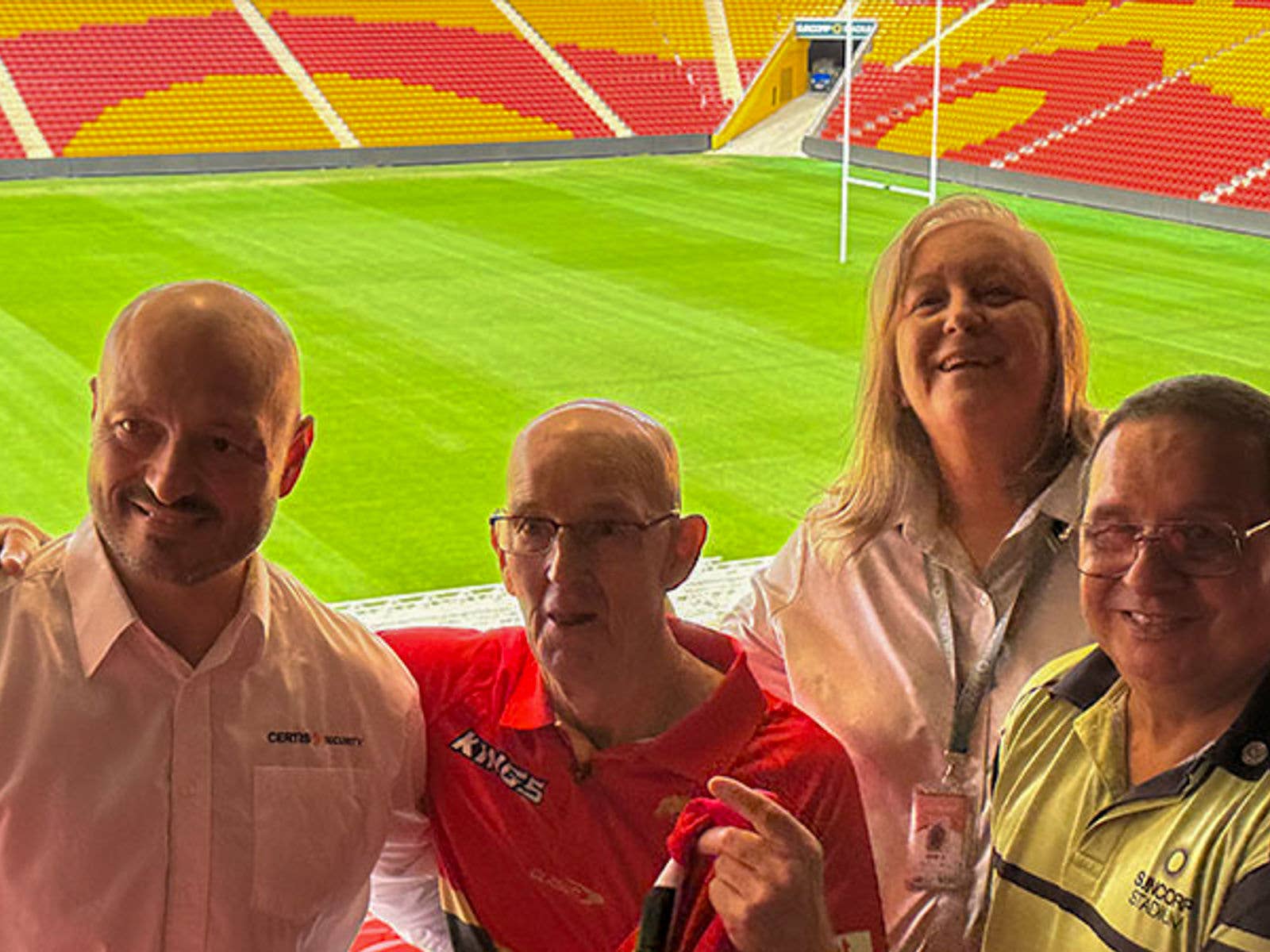 Suncorp Stadium Staff Saved A Life. Image of Certis Security Officer Adel (Far Left), patron Doug (Left), Stand Manager Deb (Right) and staff member Errol (Far Right) in front of the Suncorp Stadium field and seating bowl.