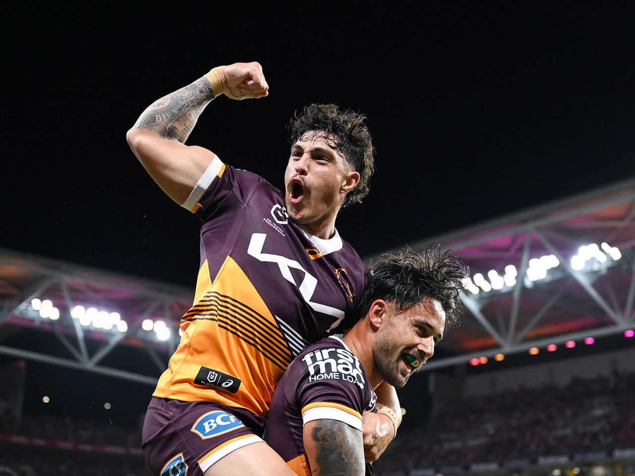 Broncos players Kotoni Staggs and Jesse Arthurs celebrate scoring a try