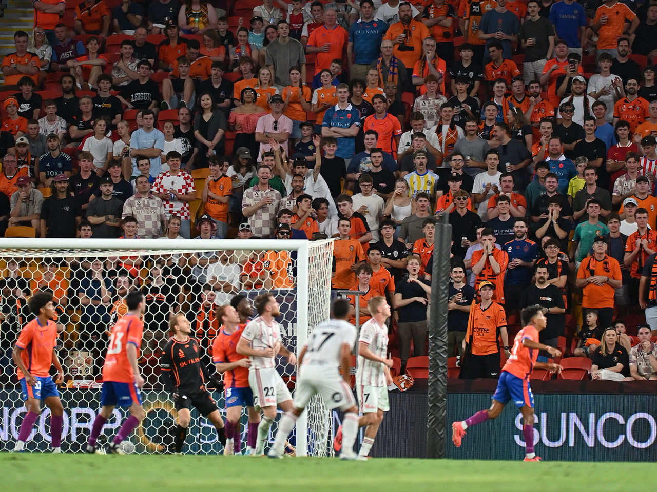 The Brisbane Roar ready to defend a cross with the Den supporters in the background