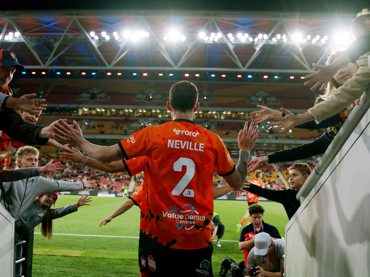 Brisbane Roar player Neville walking out through the tunnel on to the Suncorp Stadium field high fiving fans