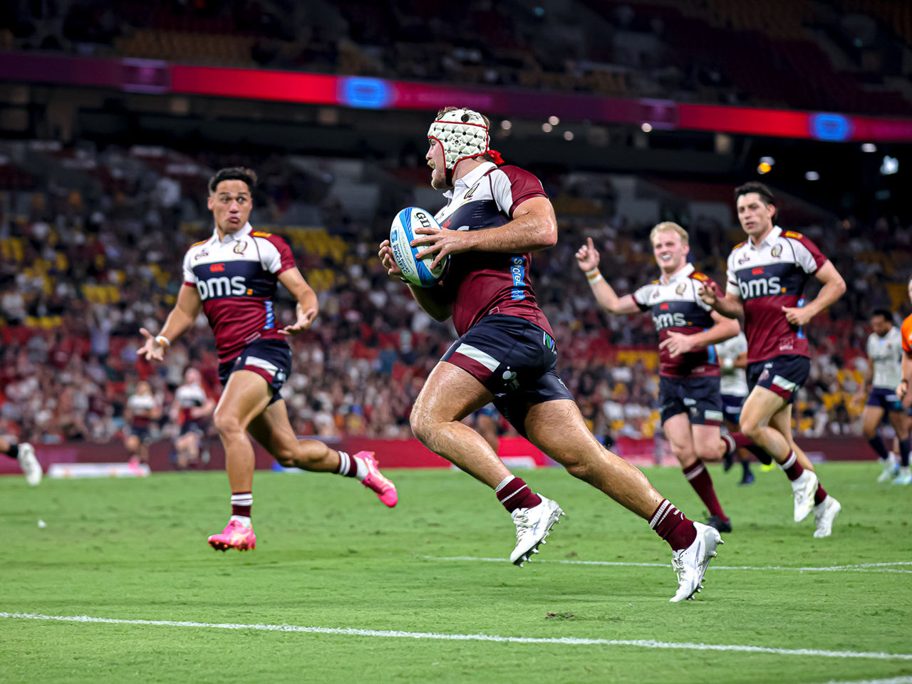 Reds player running to score a try 