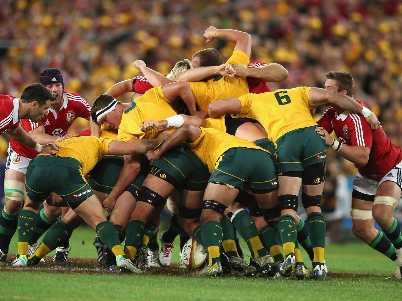 Image of Wallabies players and British and Irish Lions player midgame.