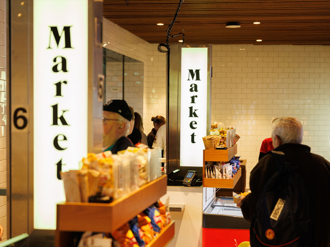 Internal view of Market outlet, showing patrons making purchases.